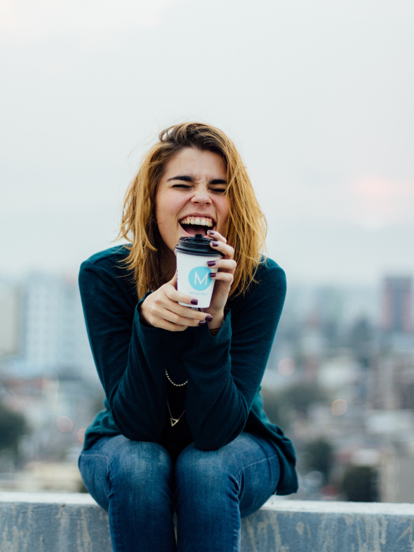 blond woman sits on a wall 