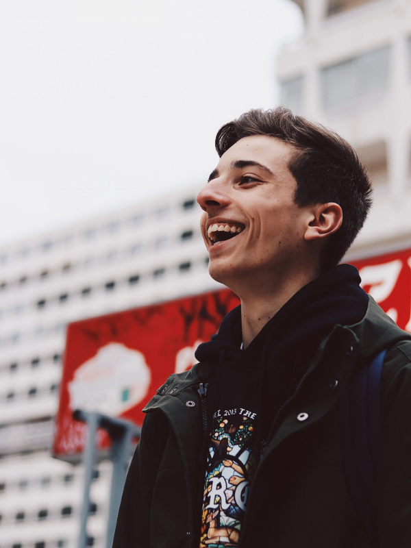 mans stands in front of a street sign